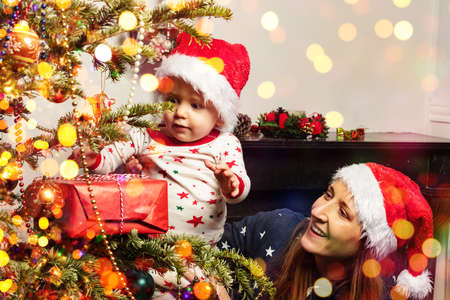 Toddler find Christmas present with mother nearの写真素材