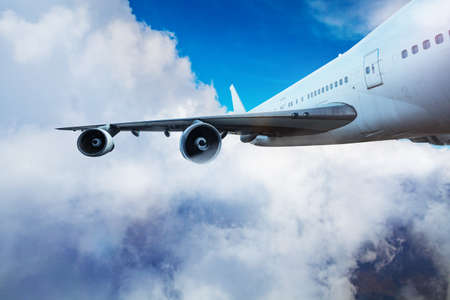 Wing and jet engines crop of an airplane flyingの写真素材