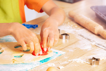 Close-up of boys hands cutting out cookies shapes
