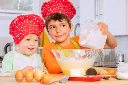 Boy pour flour to the mixing bowl cooking cookiesの写真素材