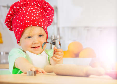 Child show heart shaped form baking at kitchenの写真素材