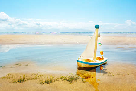 Little sail toy diy yacht in the paddle on a beachの写真素材