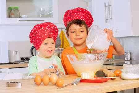 Child pour flour to the mix bowl cooking cookiesの写真素材