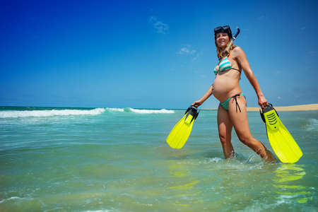 Pregnant woman walk to swim and snorkel in the seaの写真素材