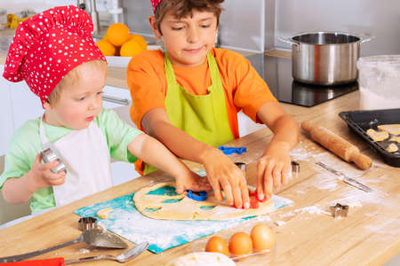 Boys hands cutting out cookies in heart shapeの写真素材