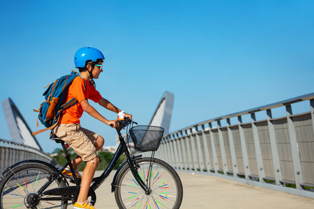 Portrait of a child ride on bicycle with backpackの写真素材