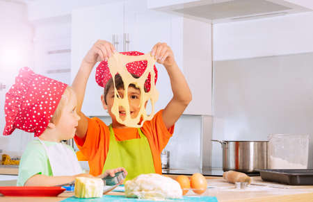Children play holding dough cutting out cookiesの写真素材