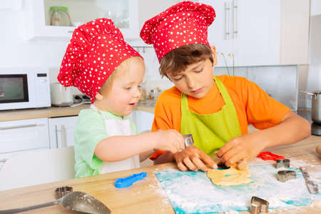Happy kids brothers cut out cookies shapes pastryの写真素材