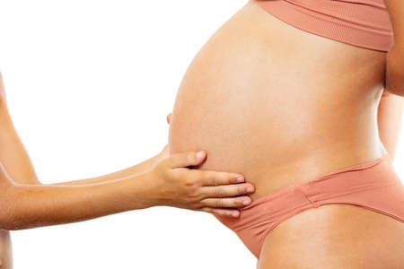 Child hands touch pregnant belly: expect a brotherの写真素材