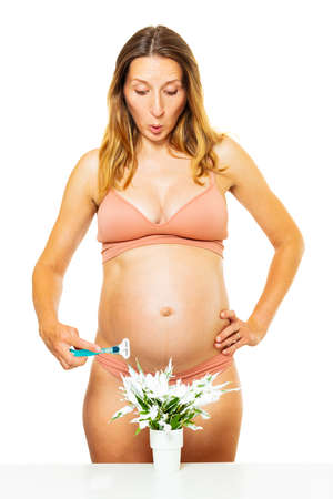 Shocked pregnant woman with razor shaving conceptの写真素材