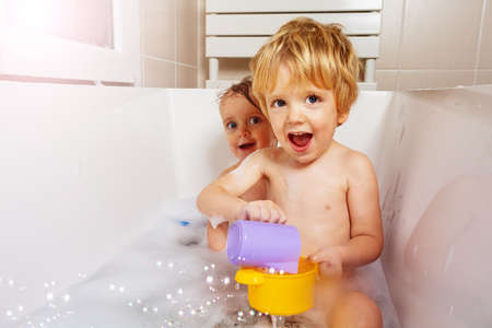 Two little babies play with soap bubbles smilingの写真素材