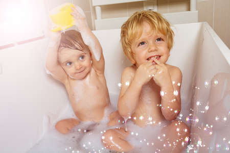 Brother and sister babies play with soap bubblesの写真素材