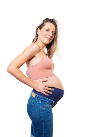 Pregnant woman smiling holing big belly over whtieの写真素材