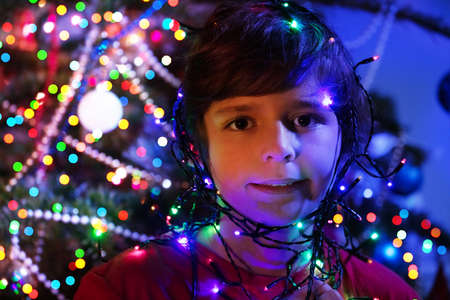Cute boy portrait with illuminated garland lightの写真素材