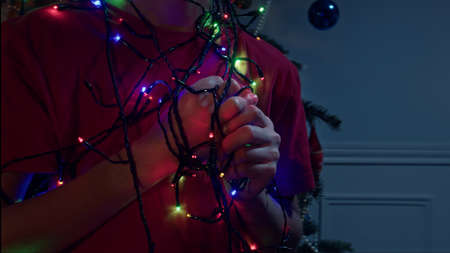 Hands of the boy with illumination garland lightsの写真素材