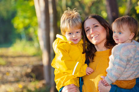 Happy mother with her son and daughter in forestの写真素材