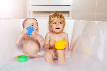 Brother and sister babies play in the bathroomの写真素材