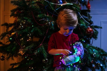 Toddler broken hand in cast illuminated by garlandの写真素材