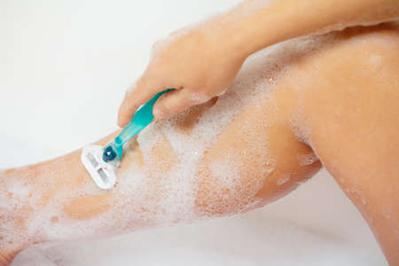 Close-up of a woman who shave legs in the bathroomの写真素材