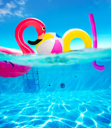 Pool text made of inflatable flamingo and other toysの写真素材