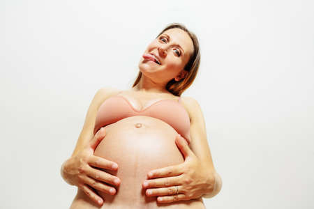 Funny pregnant woman stick out tongue look downの写真素材