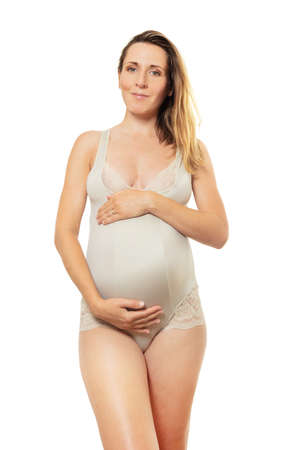 Calm pregnant woman portrait in profile over whiteの写真素材