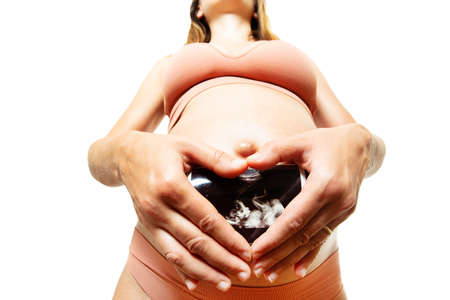 Pregnant woman hold ultrasound image in handsの写真素材