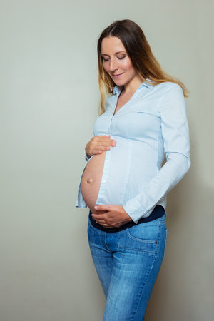 Pregnant working woman wear a shirt touch big bellyの写真素材