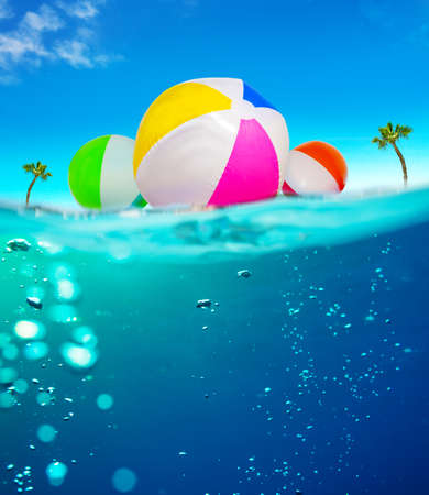 Inflatable balls float in water underwater split imageの写真素材