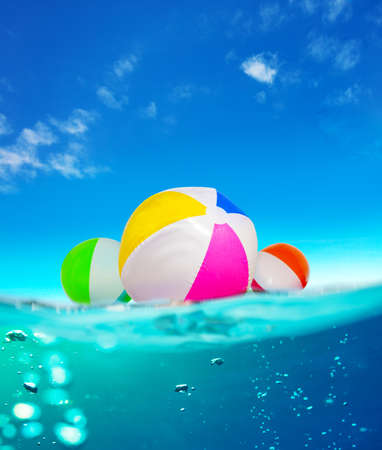 Inflatable balls float in water, split underwater sea imageの写真素材