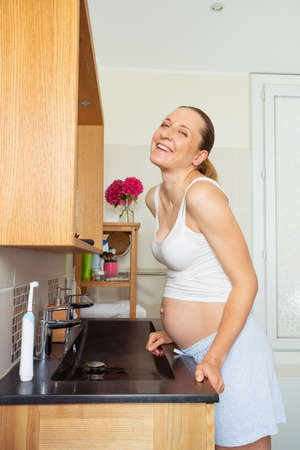 Laughing happy pregnant woman at home bathroomの写真素材