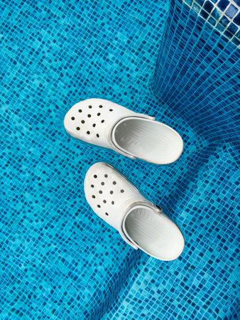 Sandals floating in the clear swimming pool water