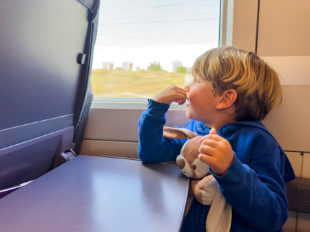 Little boy with plush toy sit and look at window in high speedの写真素材
