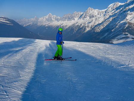 Boy stand on fresh ski track over French mountain summitsの写真素材