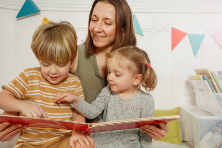 Mom reading to her children bedtime stories in their bedroomの写真素材