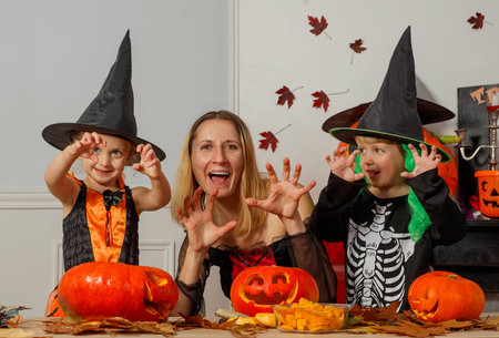 Mother and kids carve pumpkins, celebrating Halloween joyfullyの写真素材