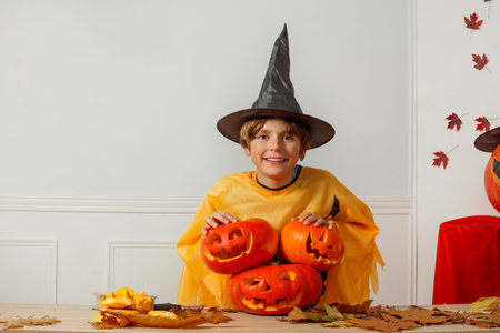 Happy teen dressed for Halloween with stacked jack-o-lanternsの写真素材