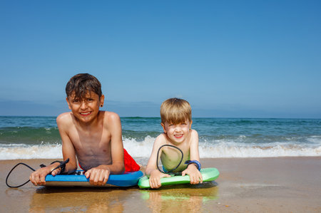 Boys laughing and riding the waves on boogie boards. Fun dayの写真素材