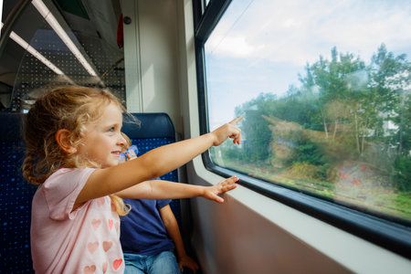 Child happily points out the window during a scenic train rideの写真素材