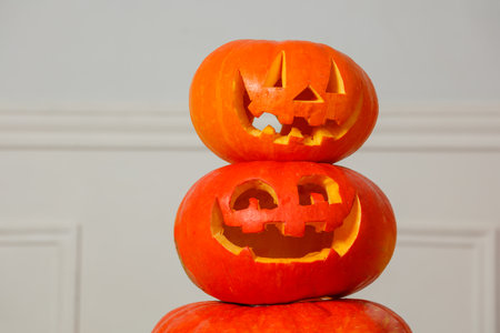 Three stacked jack-o-lanterns with carved faces for Halloweenの写真素材