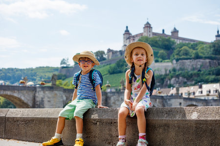 Sunny day adventure: kids exploring historic part of Wurzburgの写真素材