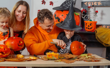 Family bonding time, carving pumpkins for a fun Halloween nightの写真素材