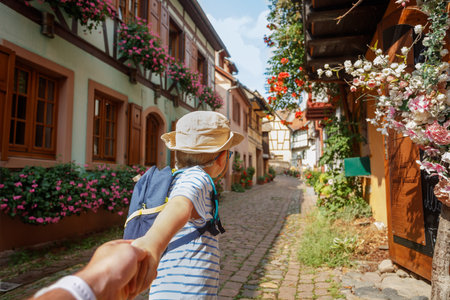 Young explorer enjoys a scenic alley stroll, hold in handの写真素材