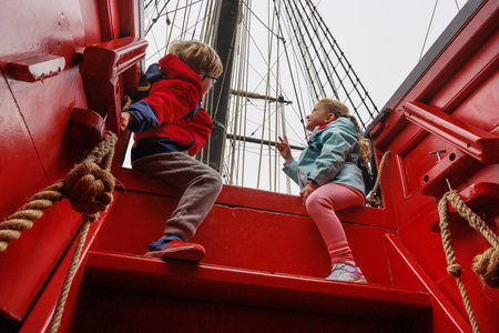 Children sit on ship stairs, talking and enjoying adventure time