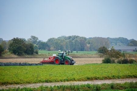 Tractor is seen cultivating the autumn field in Normandy, Franceの写真素材
