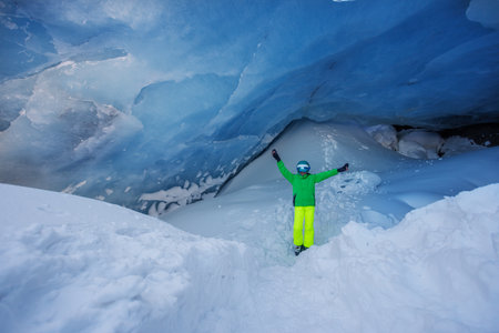 Adventurer skier stand in icy blue cave, admire wonder of natureの写真素材