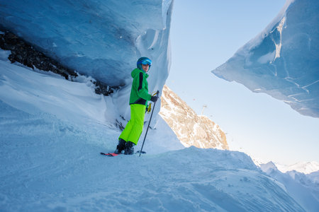 Teenage skier explore majestic blue ice cave in ancient glacierの写真素材