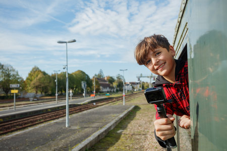 Teen films fields through train doorway using compact gimbalの写真素材