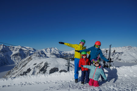 Mom and dad holding kids on ski run, ready for the first slideの写真素材