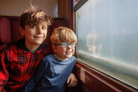 Two brothers in carriage point and talk over the window frameの写真素材